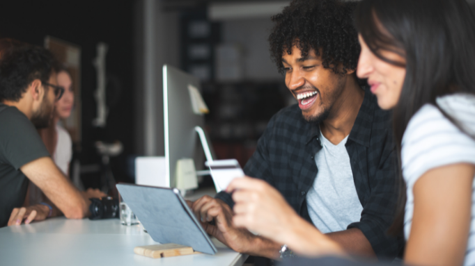 2-males-laughin-in-front-of-computer-and-holding-credit-card