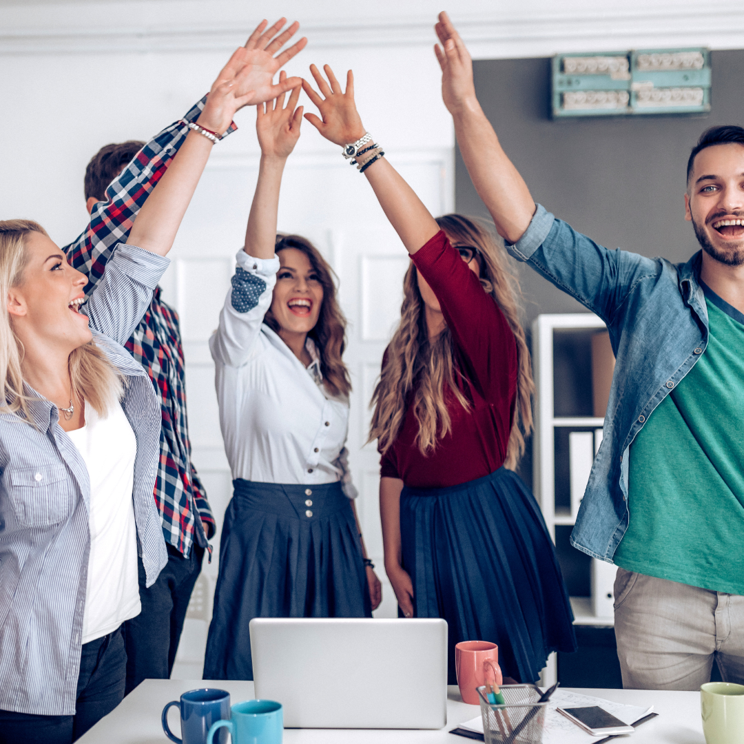 Group-of-people-celebrating-with-hands-in-air-in-office