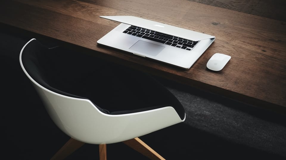 macbook-on-desk-with-white-chair