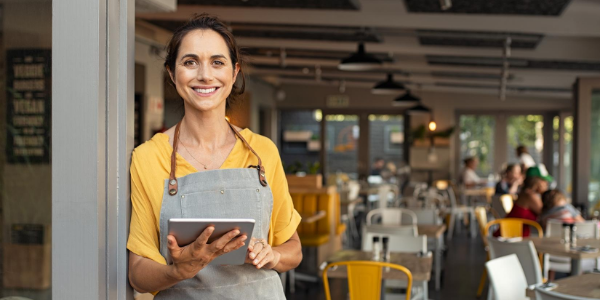 smiling small business owner holding iPad