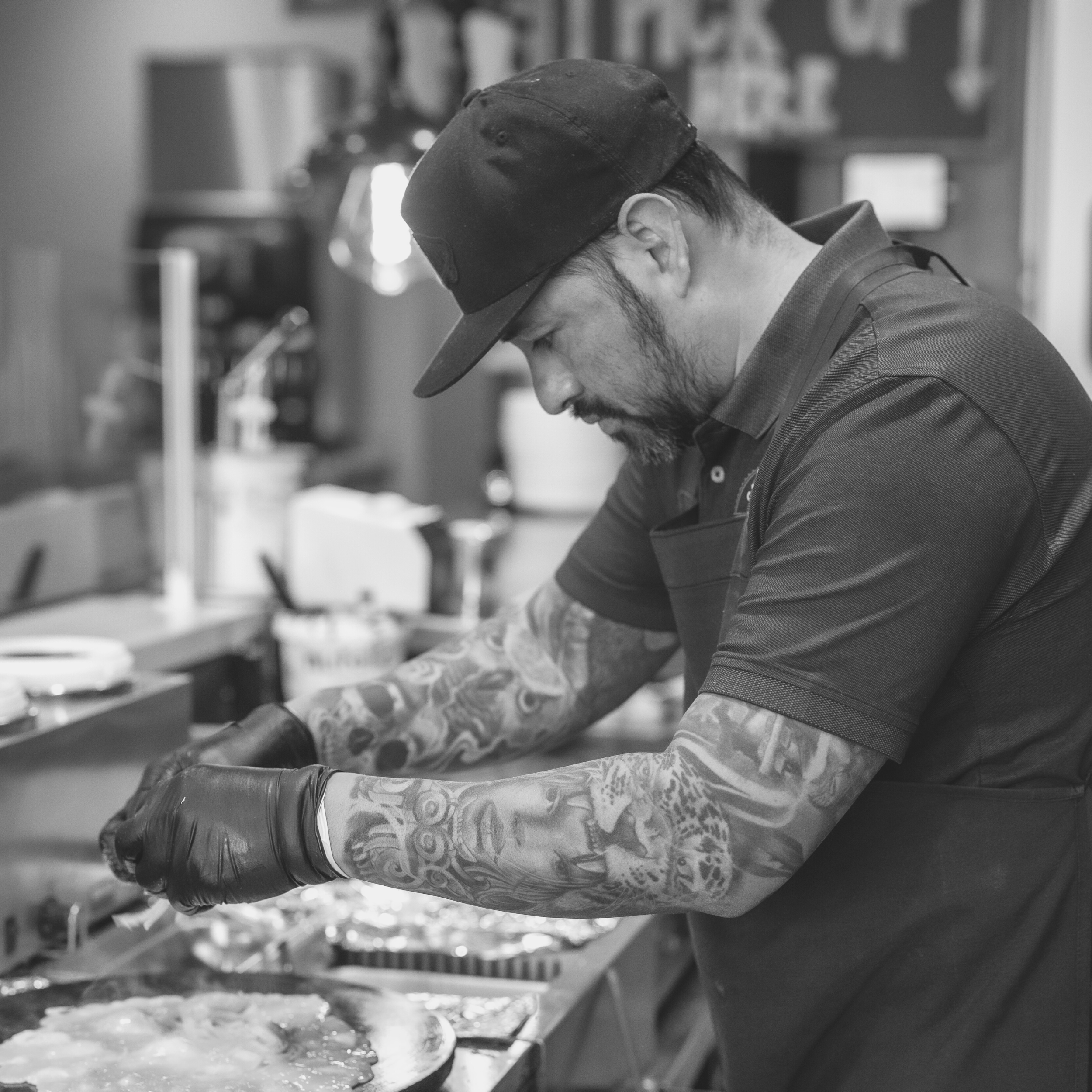 cook-preparing-meal-in-restaurant-with-tattoos-on-arms