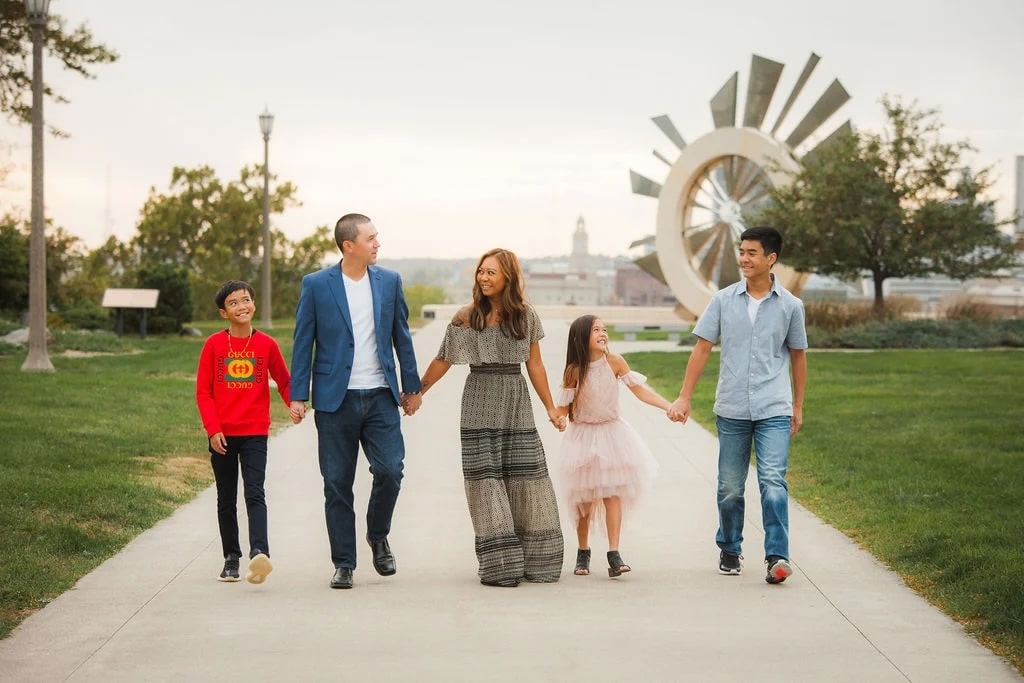 Austin Mac Nab & his family walking, holding hands, and smiling at park